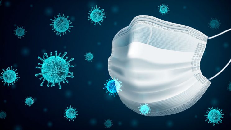 Illustration of a surgical mask amidst oversized virus cells.